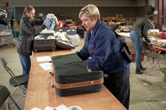 Polizistin Blanche (Isabella van Hecke) hilft, die Gepäckstücke zu sortieren und zu bestimmen.